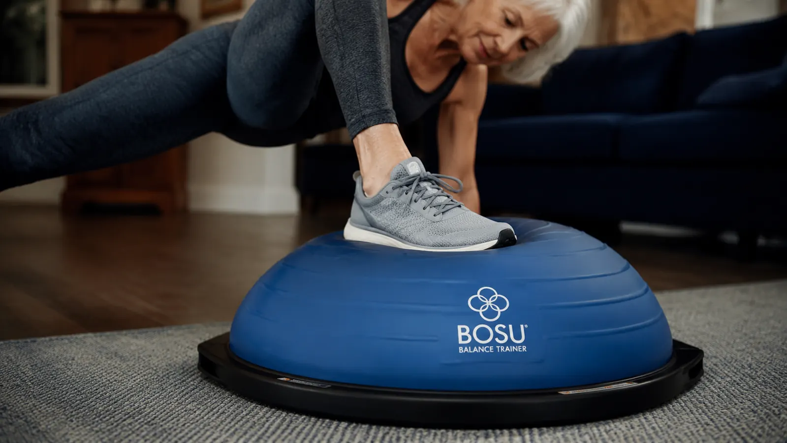 Close-up of a BOSU Balance Trainer dome surface with a person's sneaker pressing down on it, showing the give of the inflated dome