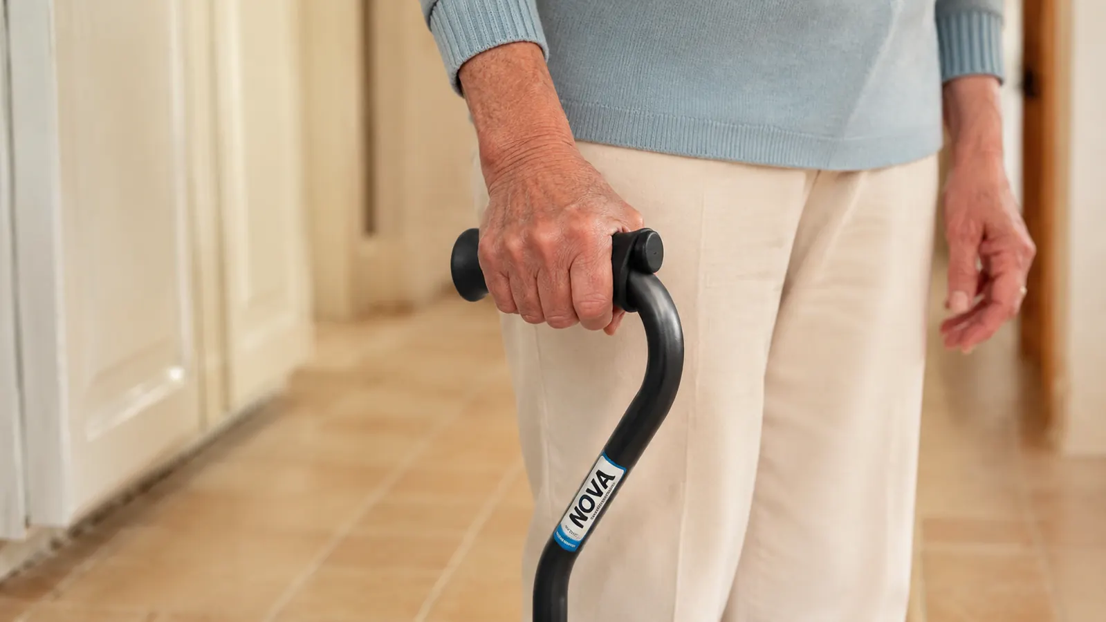 Close-up of a hand gripping an offset handle cane showing the ergonomic handle position and wrist alignment